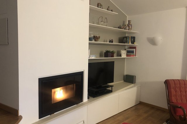 Parete soggiorno con camino, TV e mensole