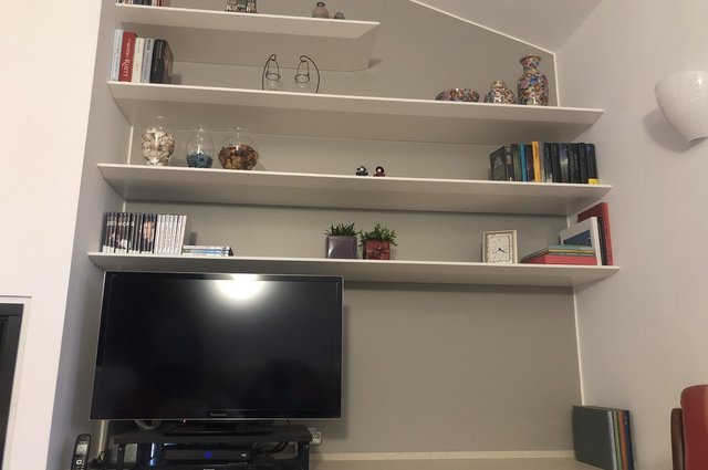 Parete soggiorno con camino, TV e mensole
