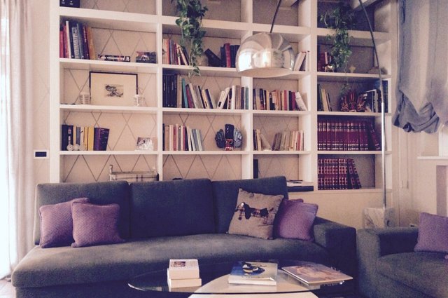 Libreria soggiorno a tutta parete con divano