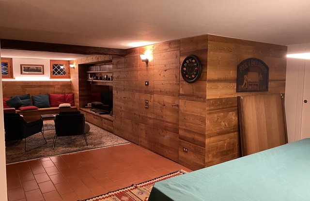 Taverna rivestita in legno con mobile bar e camino