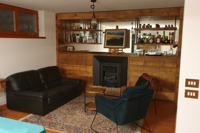 Taverna rivestita in legno con mobile bar e camino