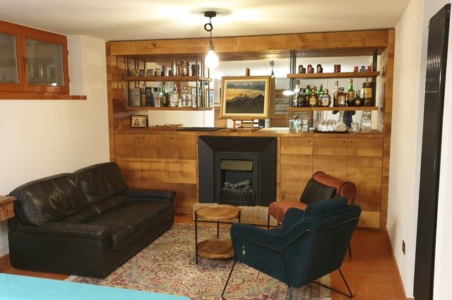 Taverna rivestita in legno con mobile bar e camino