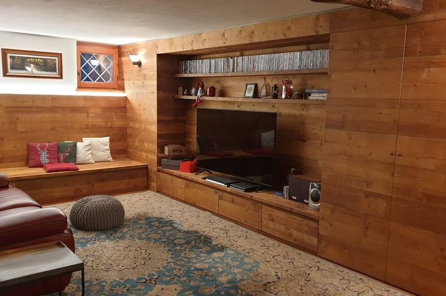 Taverna rivestita in legno con mobile bar e camino