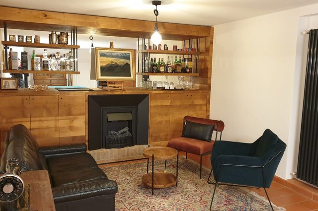 Taverna rivestita in legno con mobile bar e camino