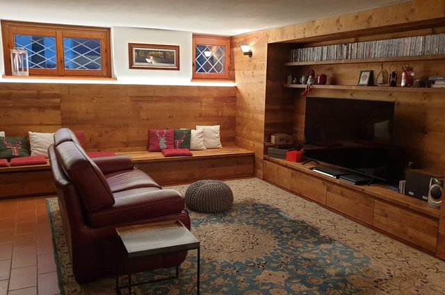 Taverna rivestita in legno con mobile bar e camino