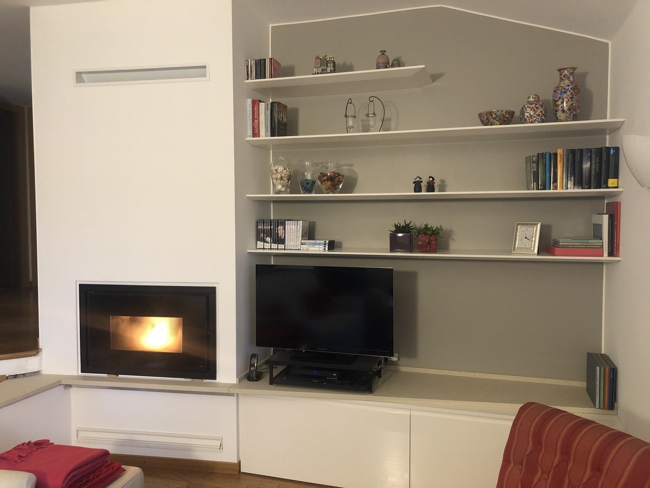 Soggiorno su misura con mensole e contenitori