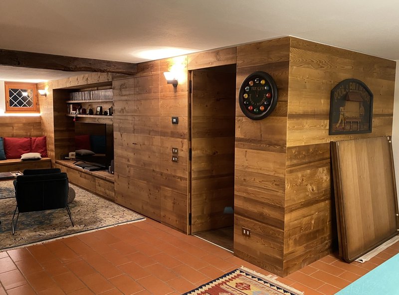 Taverna rivestita in legno con mobile bar e camino